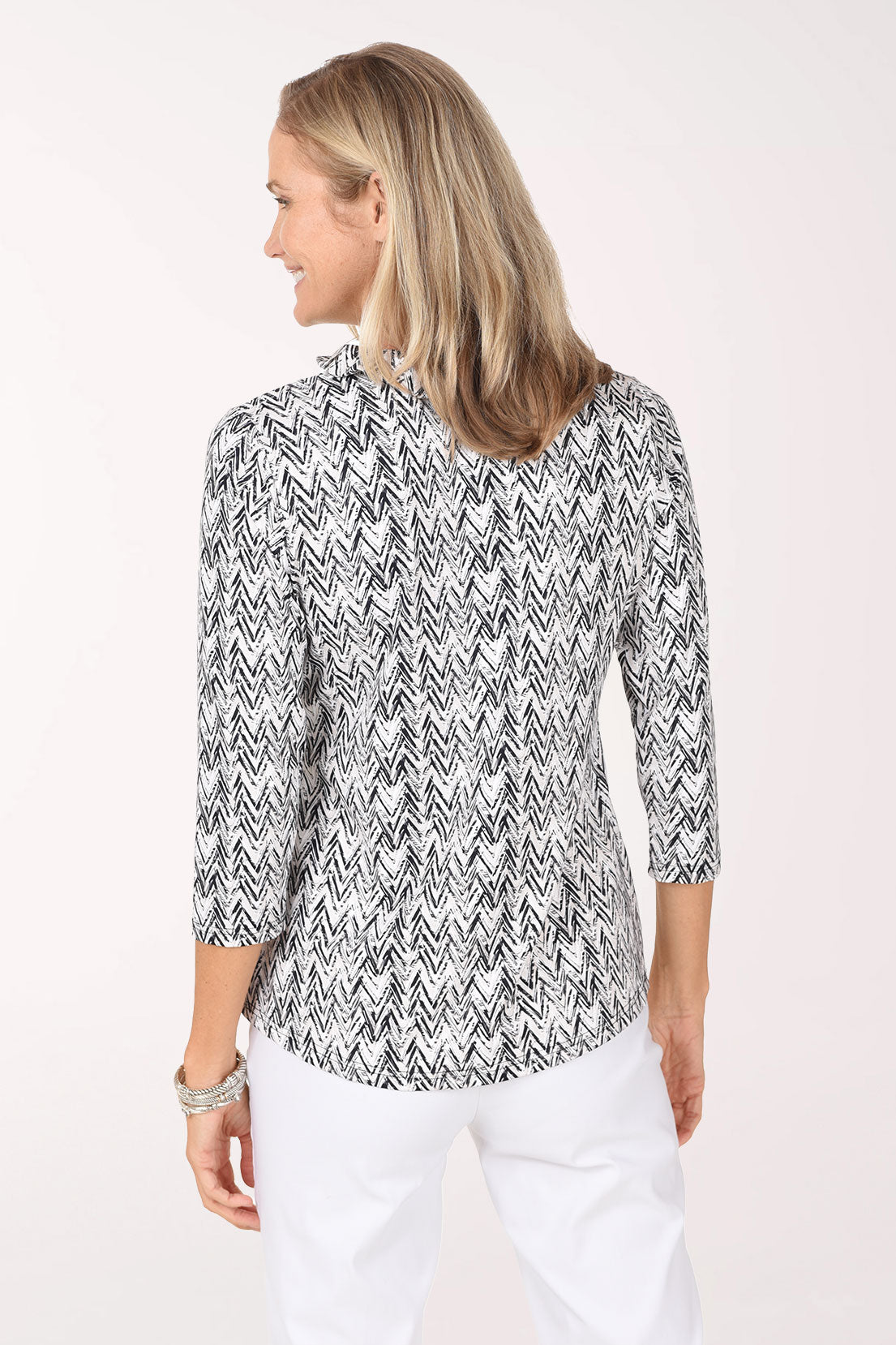 Back view of the Neutral Chevron Ruffle Neck Top showing the all-over chevron print and straight hem.