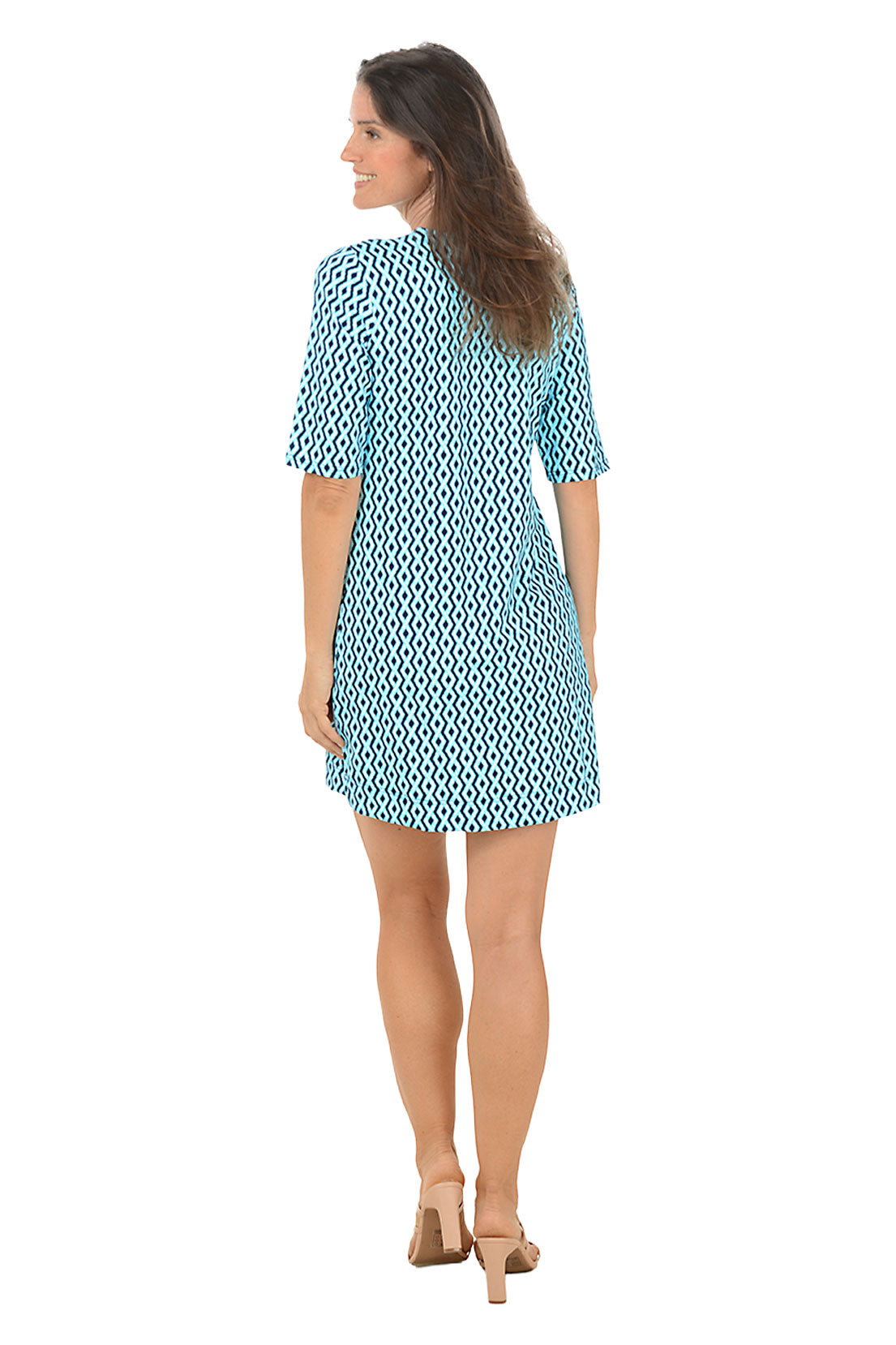 Woman wearing a blue patterned dress on a white background. Back shot.