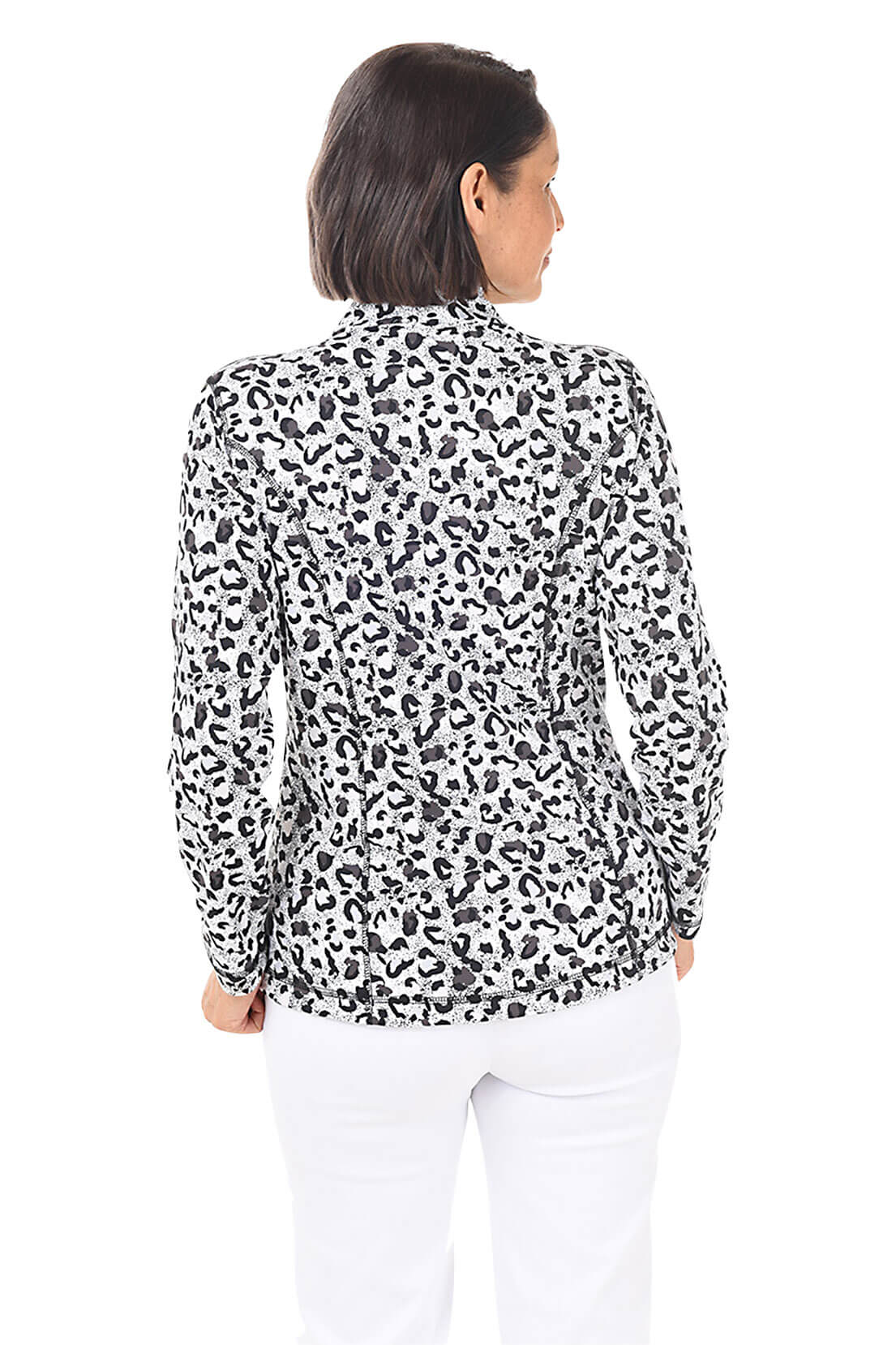 A woman wearing a black and white leopard-spotted zip front jacket and white pants in front of a white background. Back shot.