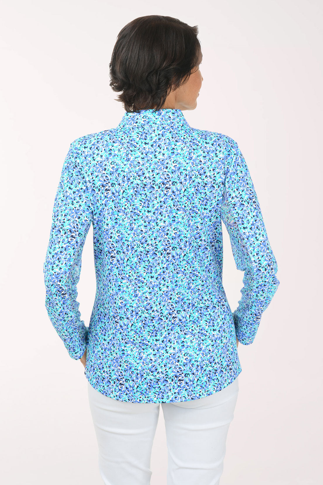 Woman wearing a floral patterned long-sleeve shirt on a white background