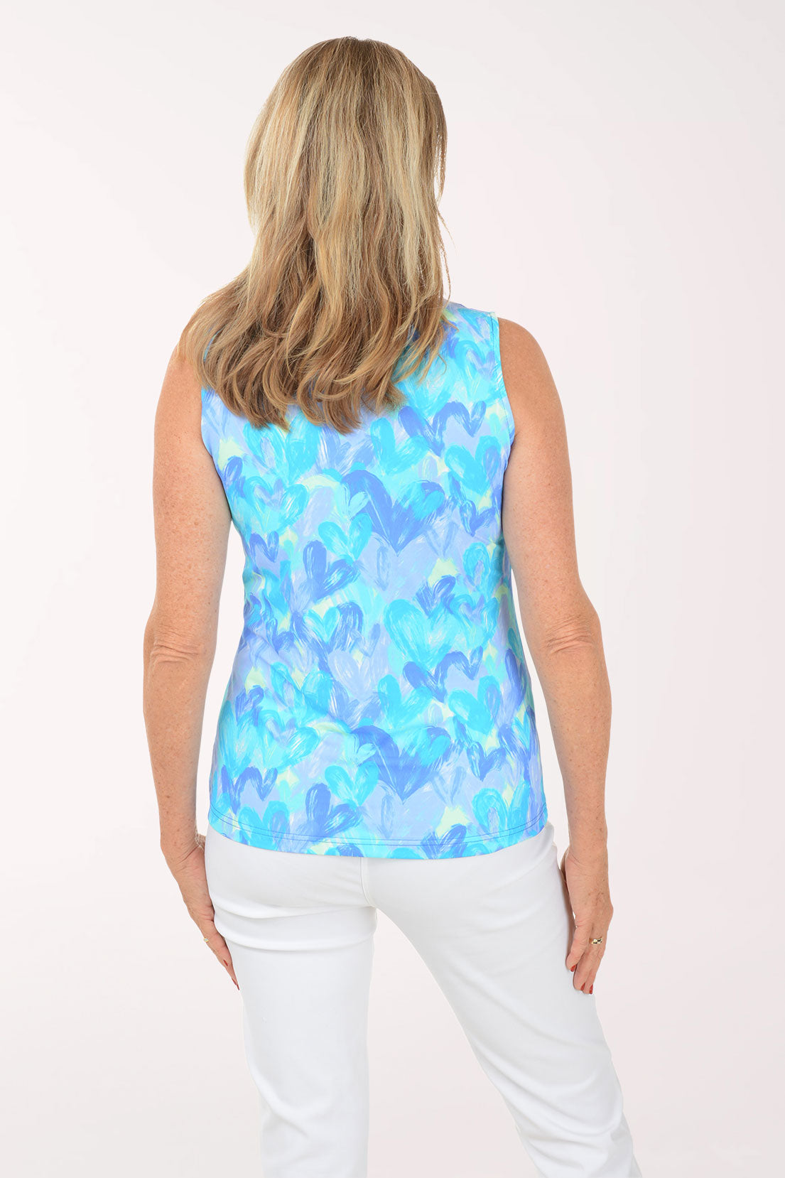Woman wearing a blue floral sleeveless top against a white background