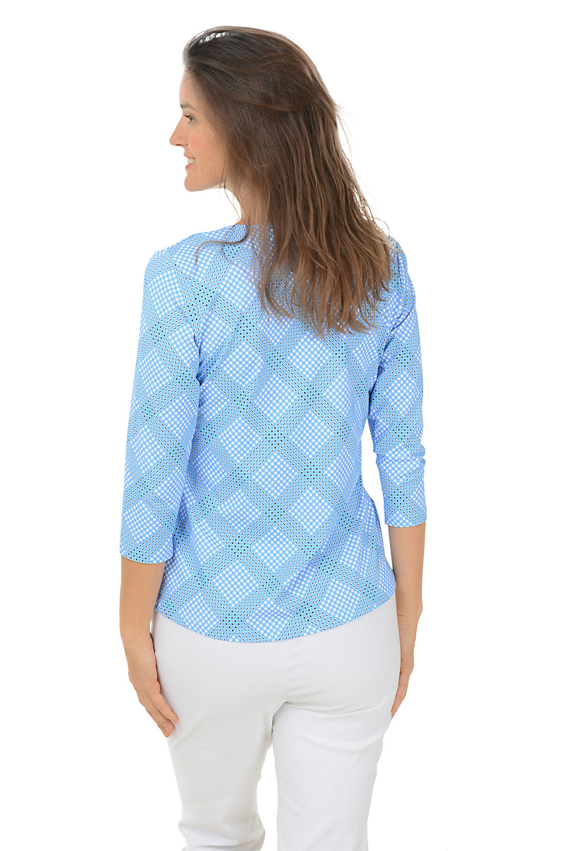 A woman wearing a blue checkered V-neck top with 3/4 sleeves, paired with white pants. Back shot.