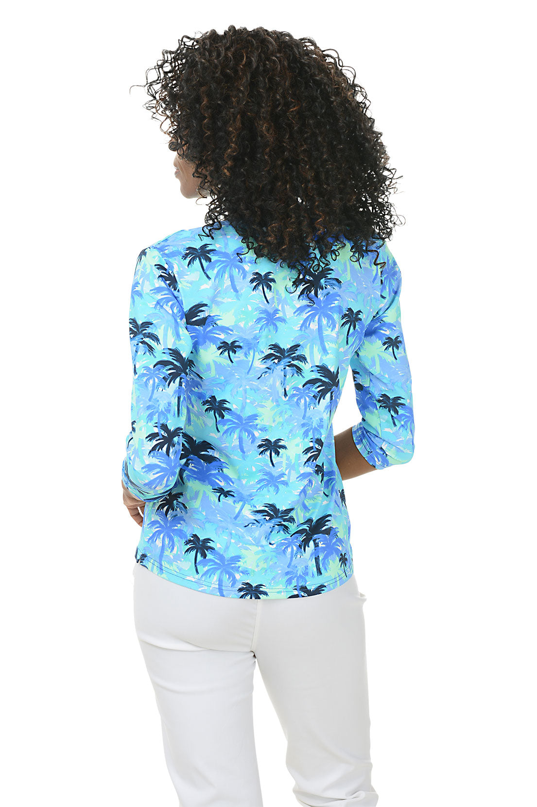 Woman wearing a blue palm tree patterned blouse on a white background. Back shot.