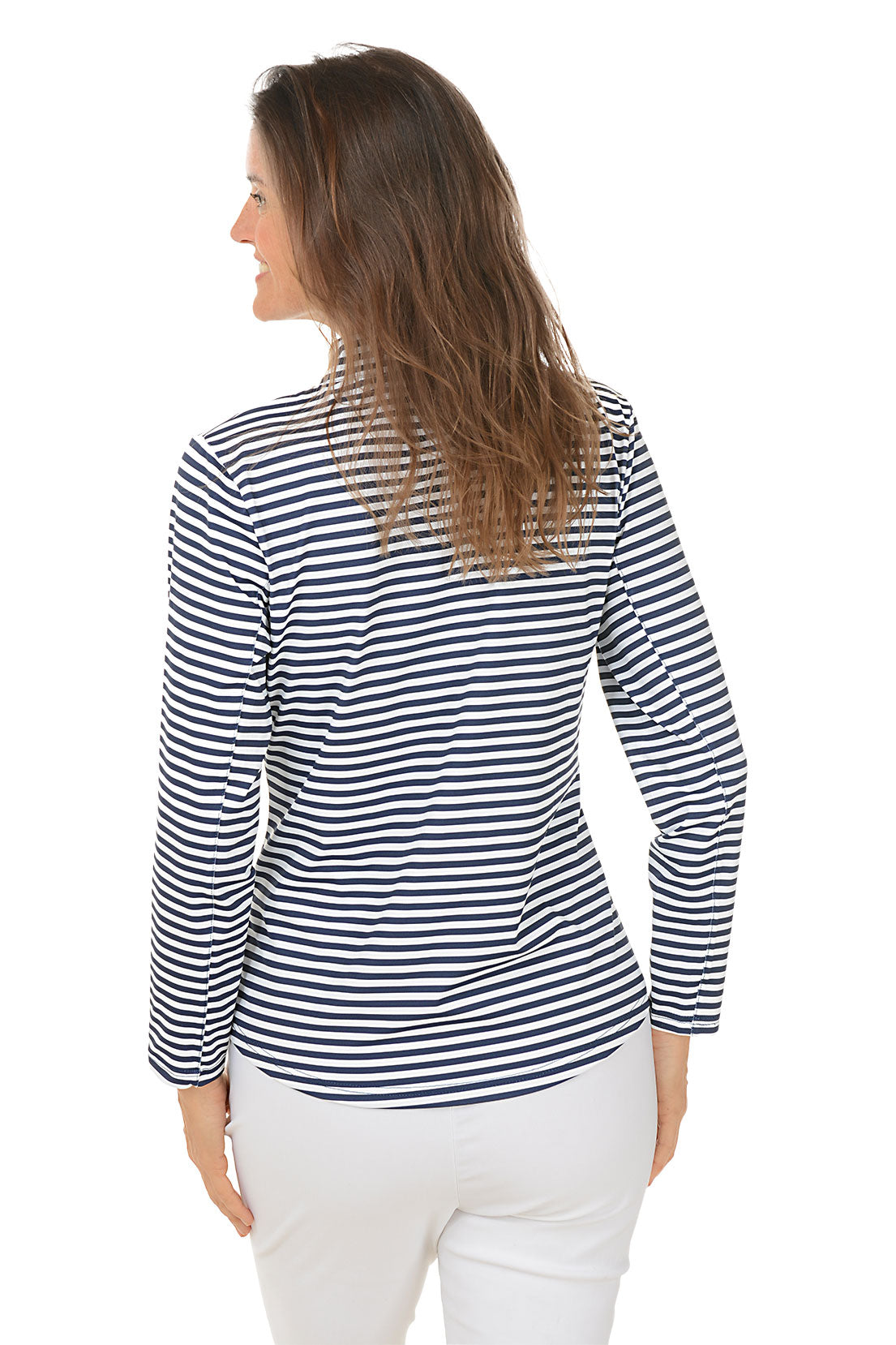 A woman wearing a navy and white striped mock neck long sleeve top with a zippered half placket, paired with white pants. Back shot.