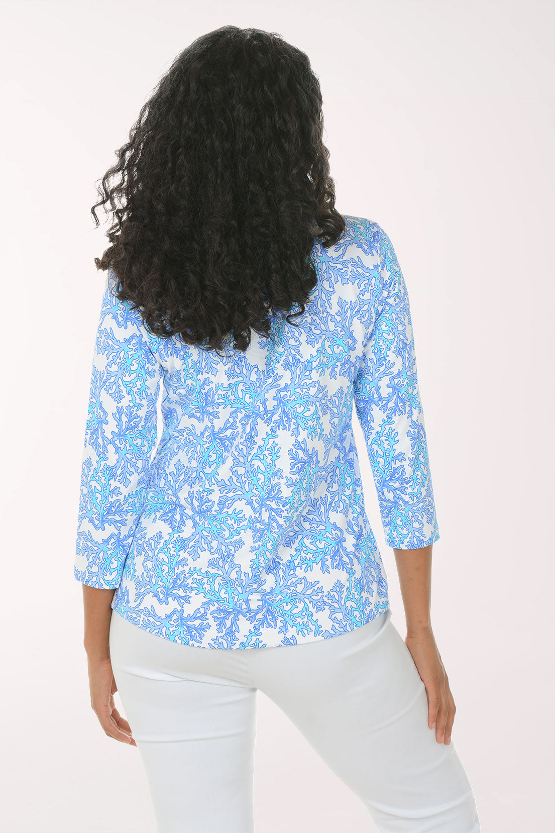 Woman wearing a blue floral blouse with a white background
