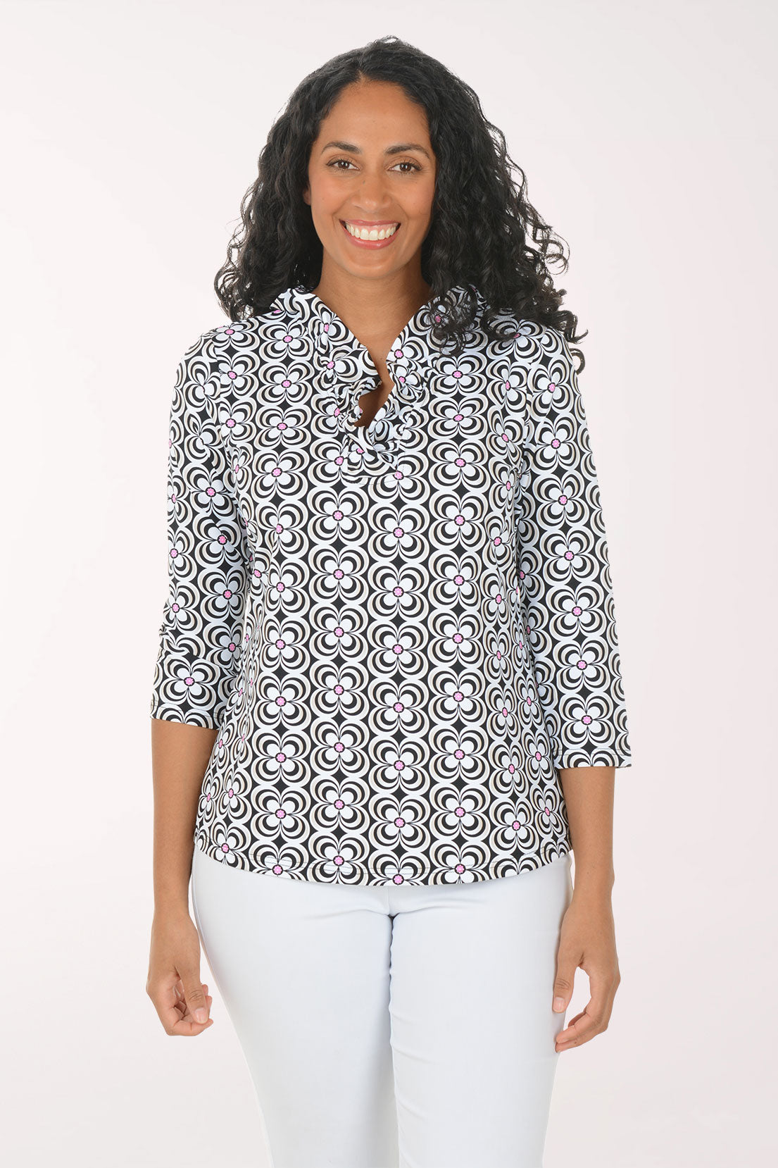 Woman wearing a patterned blouse and white pants on a white background