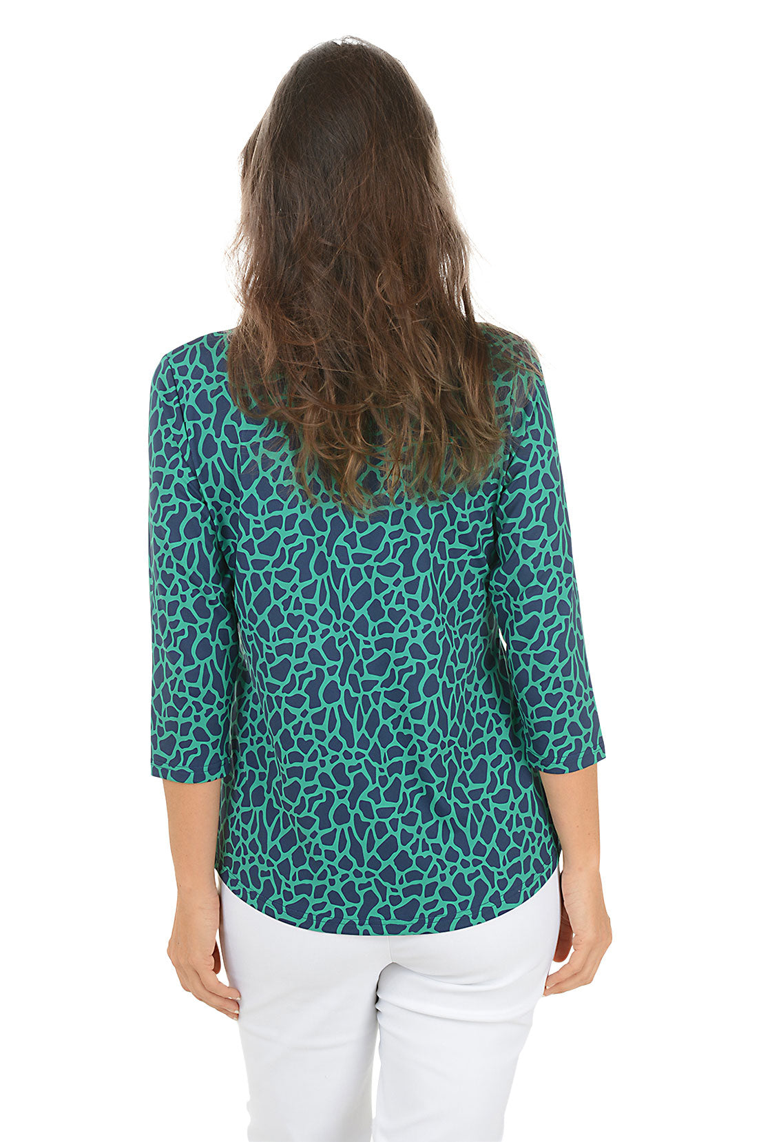 Woman wearing a teal leopard print shirt and white pants on a white background. Back shot.