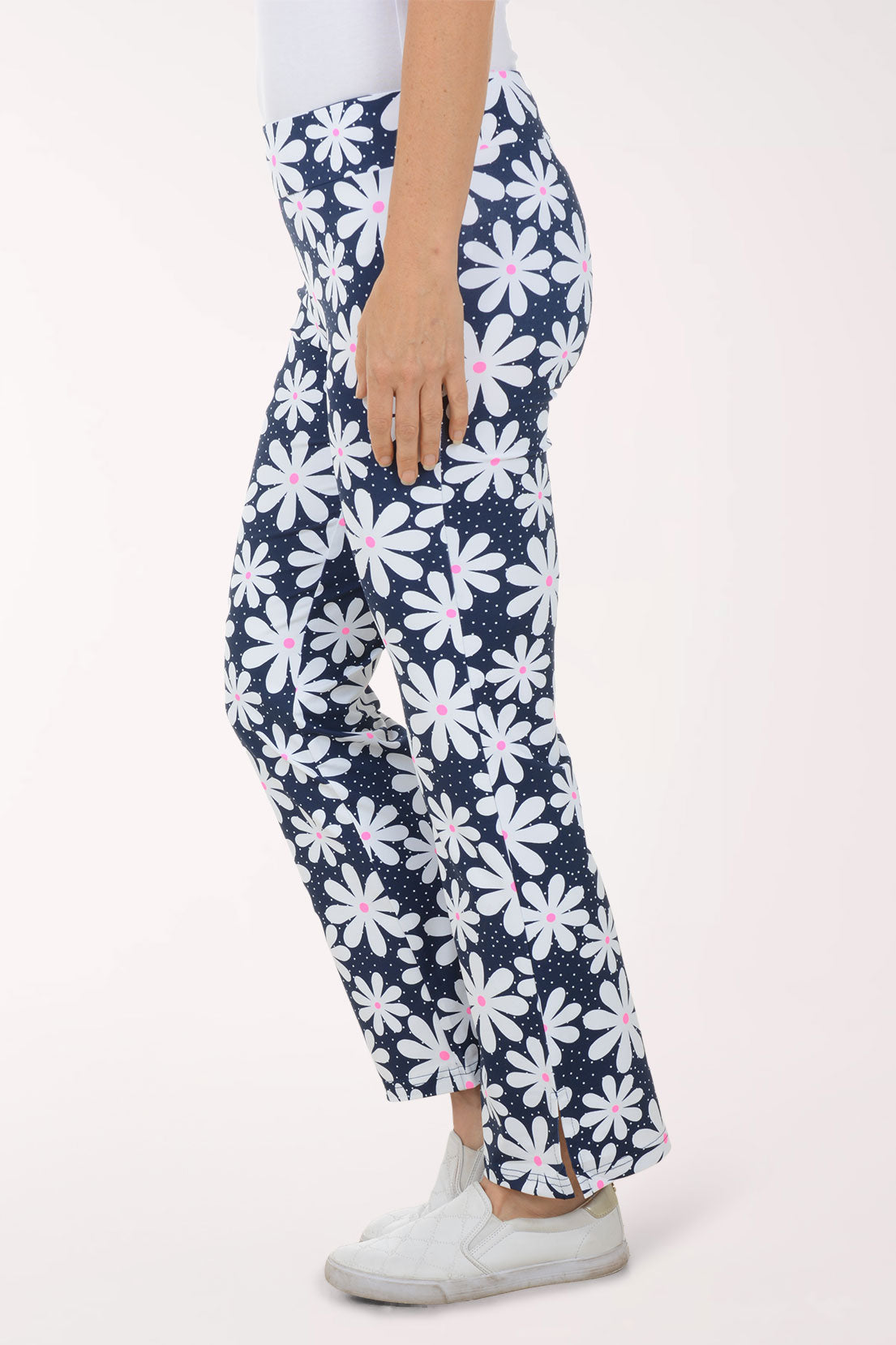 Navy pants with white floral pattern worn by a person on a white background