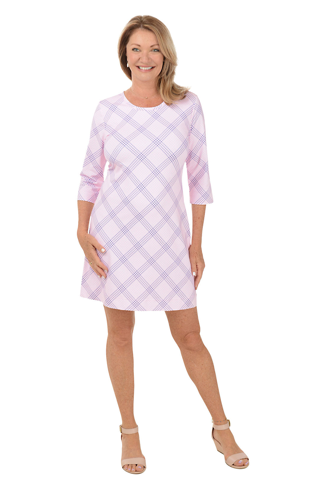 A woman wearing a pink and white gingham dress with 3/4 sleeves and a scoop neckline.