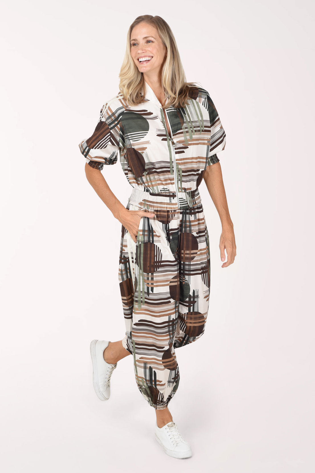 Woman wearing camouflage plaid patterned ankle length joggers with contrast stripes on side leg.