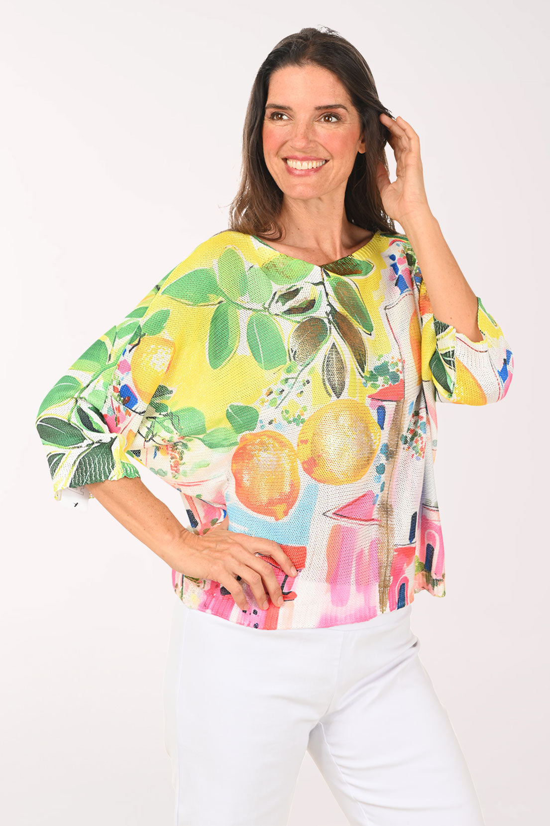 Woman wearing a colorful shirt with fruit design on a white background