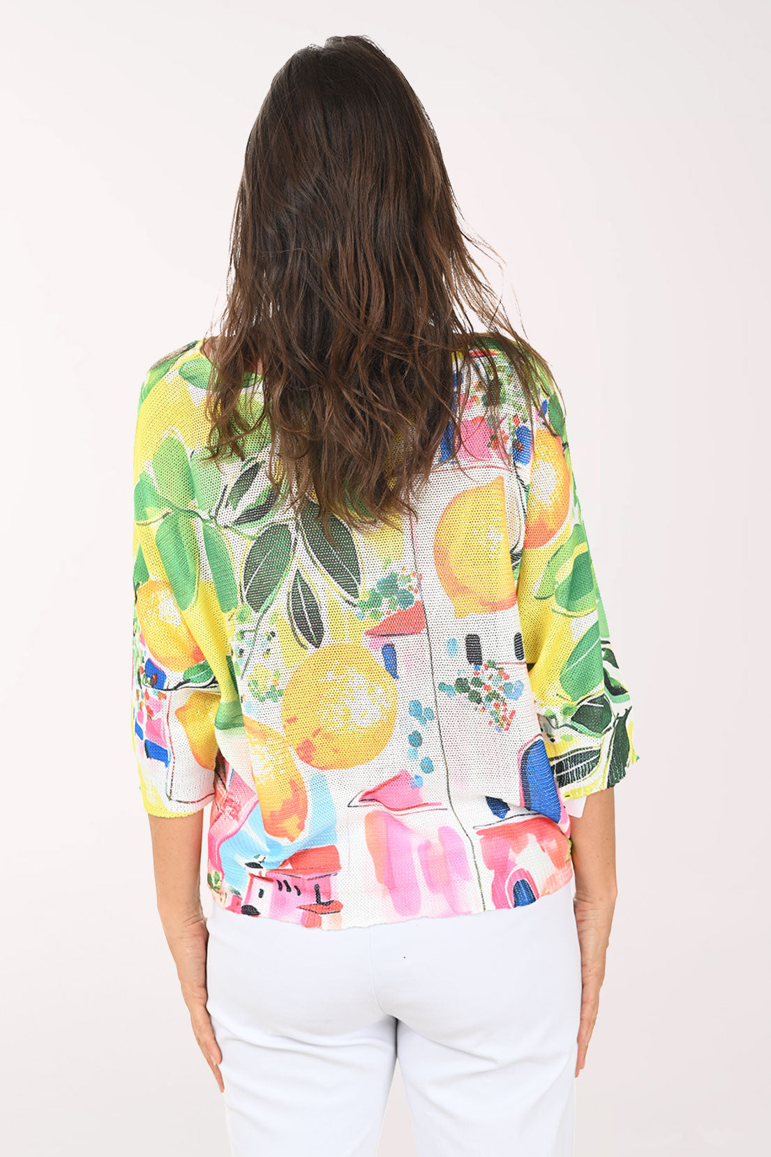 Woman wearing a colorful shirt with fruit design on a white background