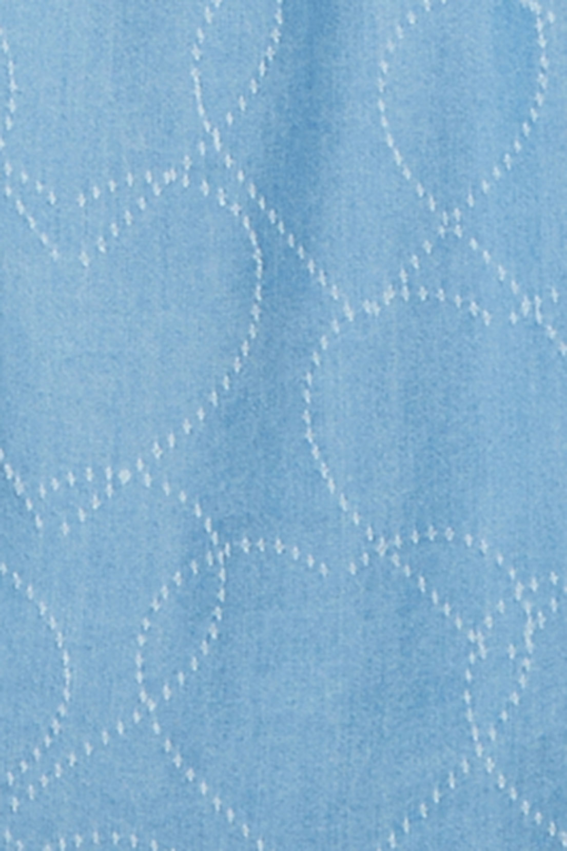 Close-up of the light blue lyocell fabric showing the white stitched heart embroidery.