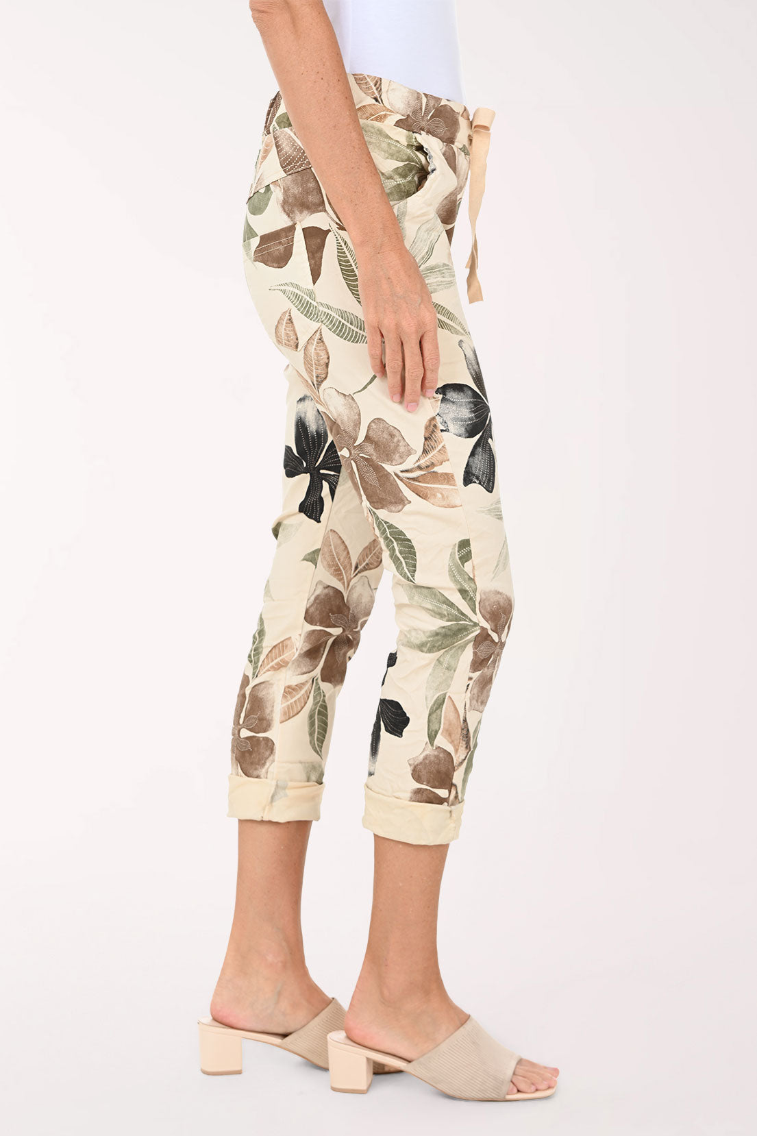 Capri pants with floral pattern worn by a person on a white background