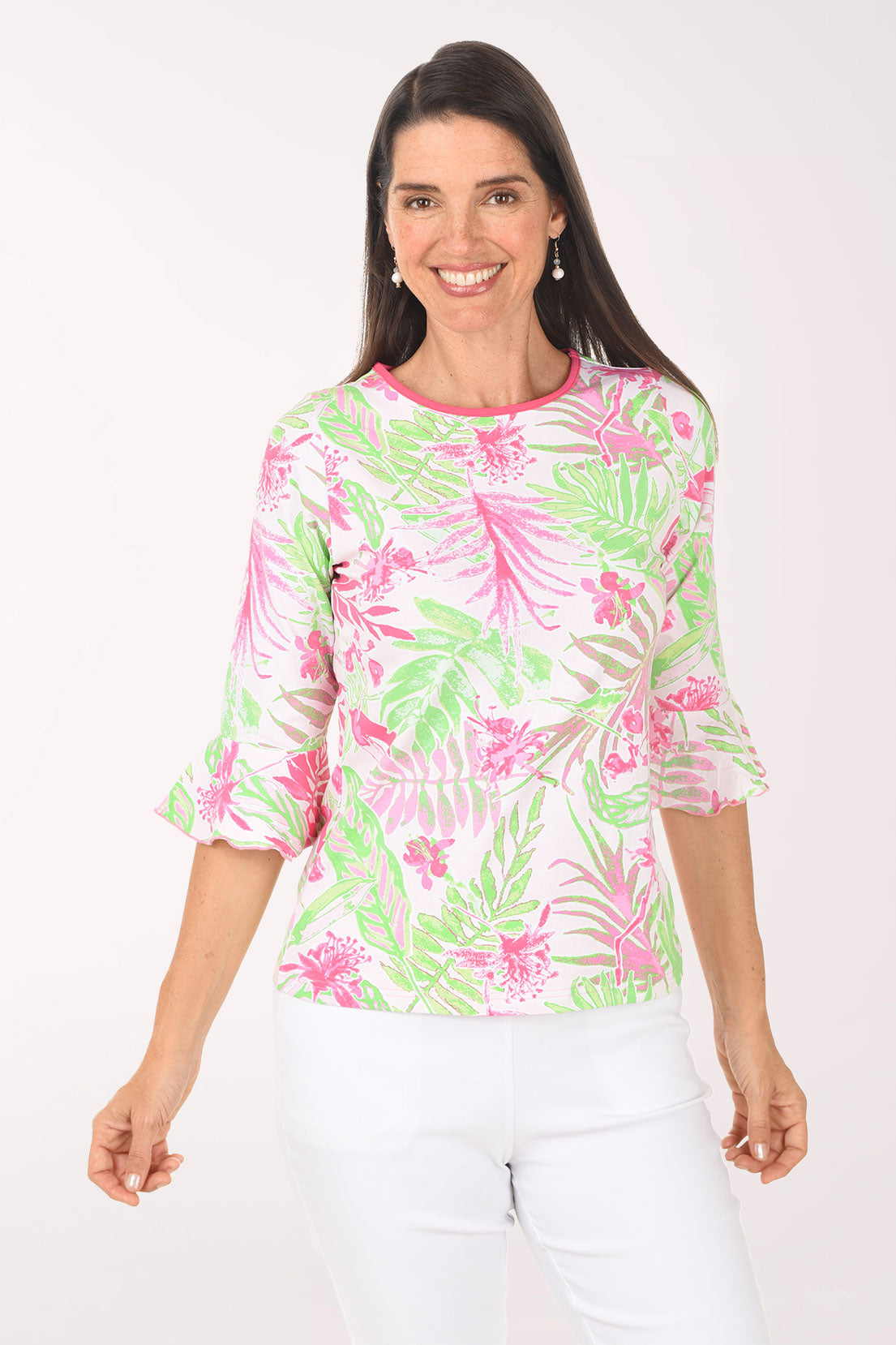 Woman wearing a colorful tropical print shirt on a white background
