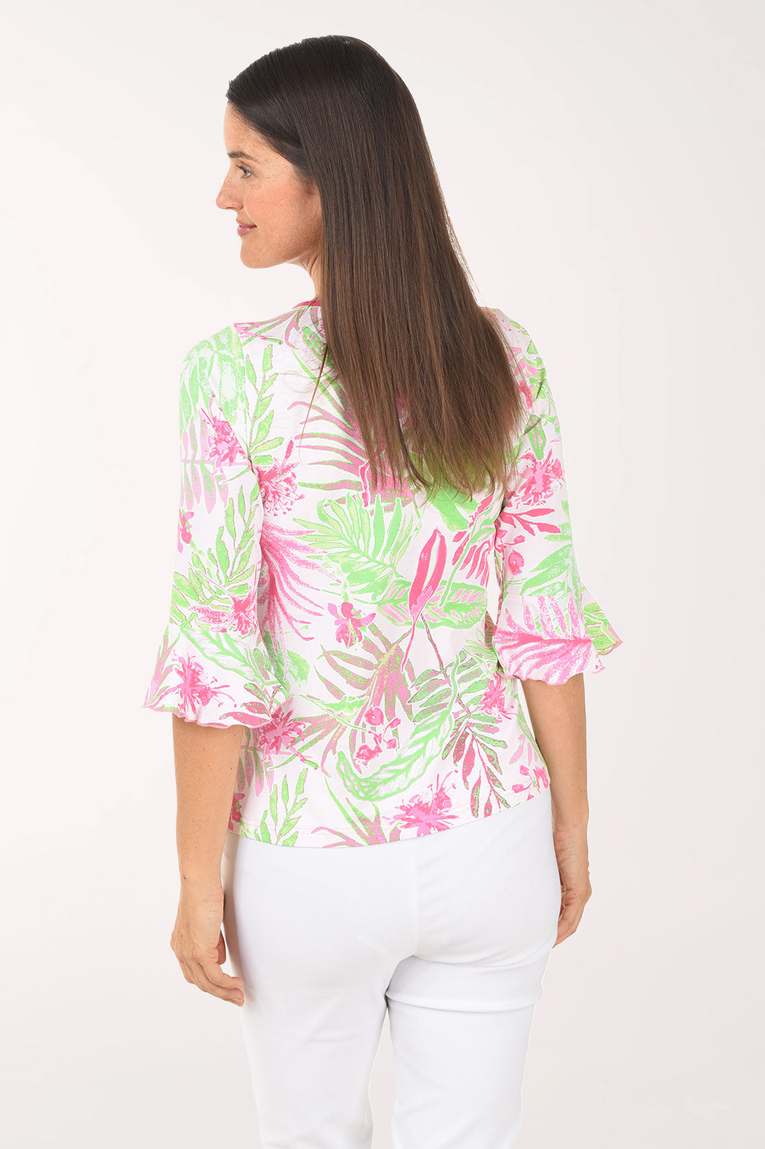 Woman wearing a colorful tropical print shirt on a white background