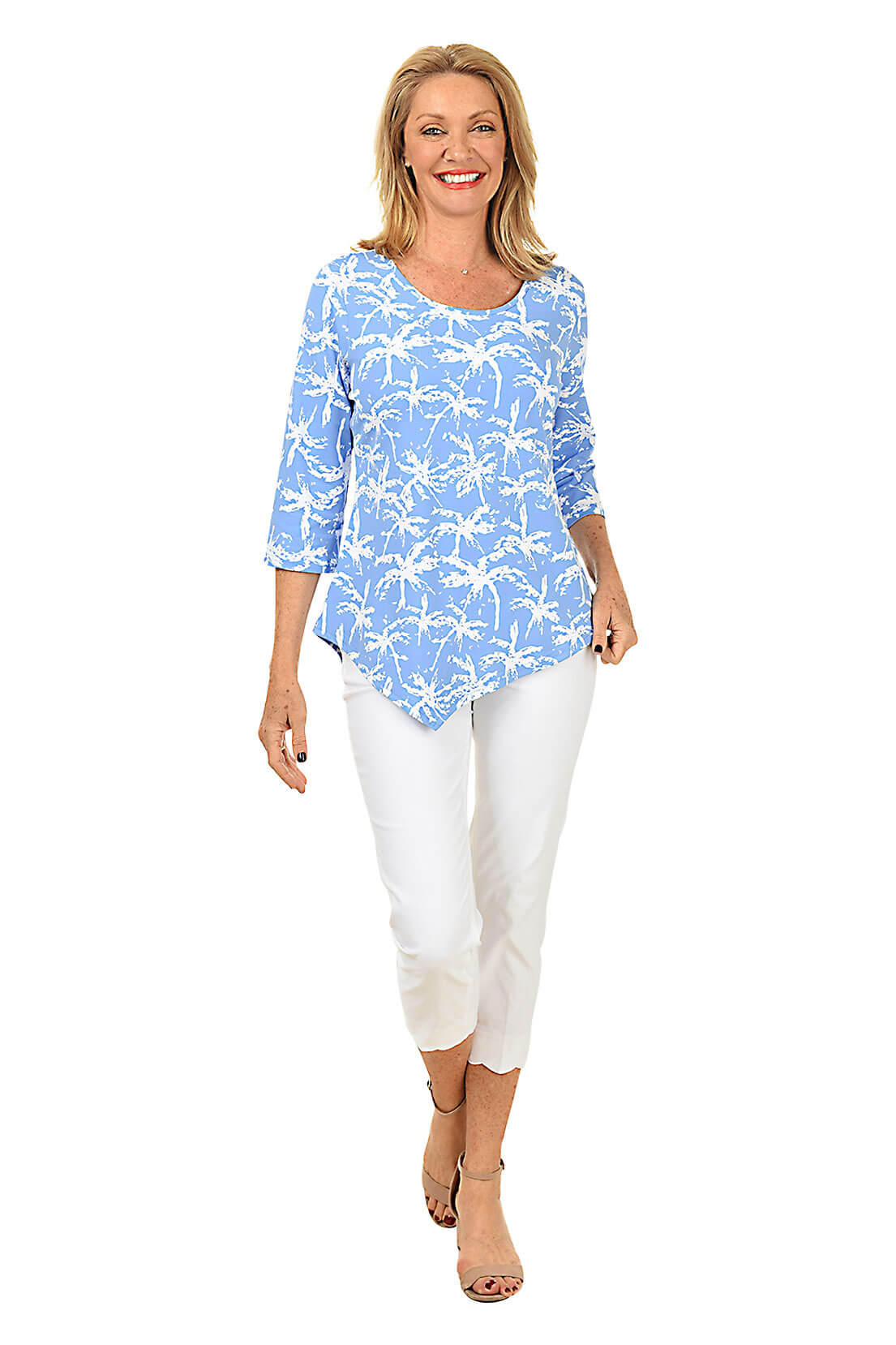 Woman wearing a blue floral top and white pants on a white background