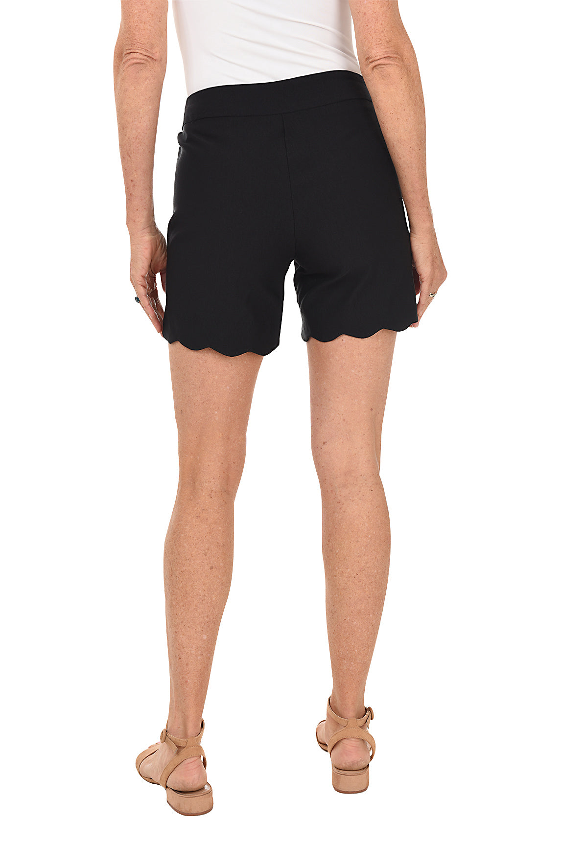 A model wearing black pull-on stretch scallop shorts with small front pockets and a flat back design. Back shot.