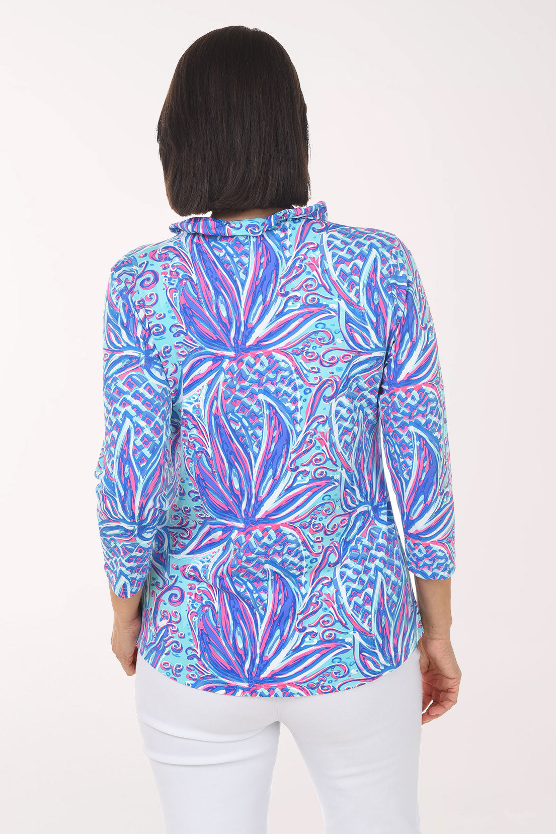 Woman wearing a colorful patterned blouse on a white background