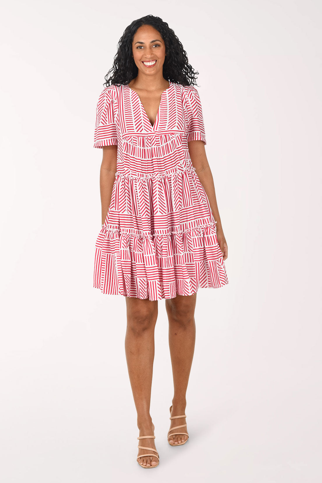 Woman wearing a red and white patterned dress on a white background