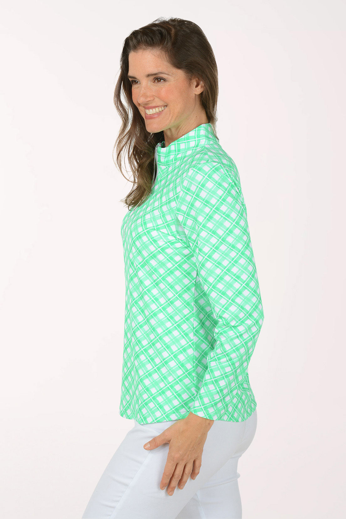 A woman wearing a long sleeve green plaid activewear top.
