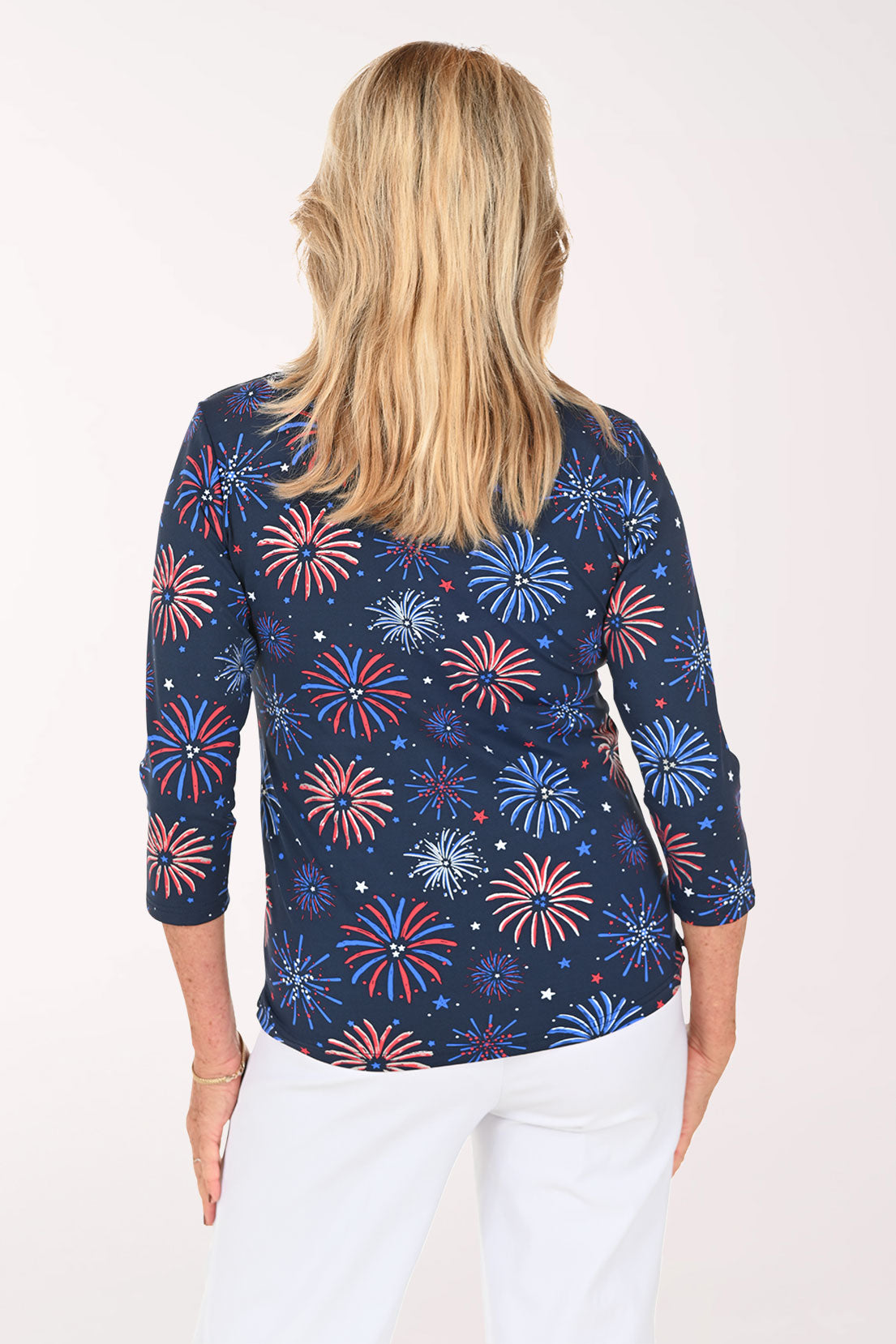 Woman wearing a navy 3/4 sleeve top with a firework print