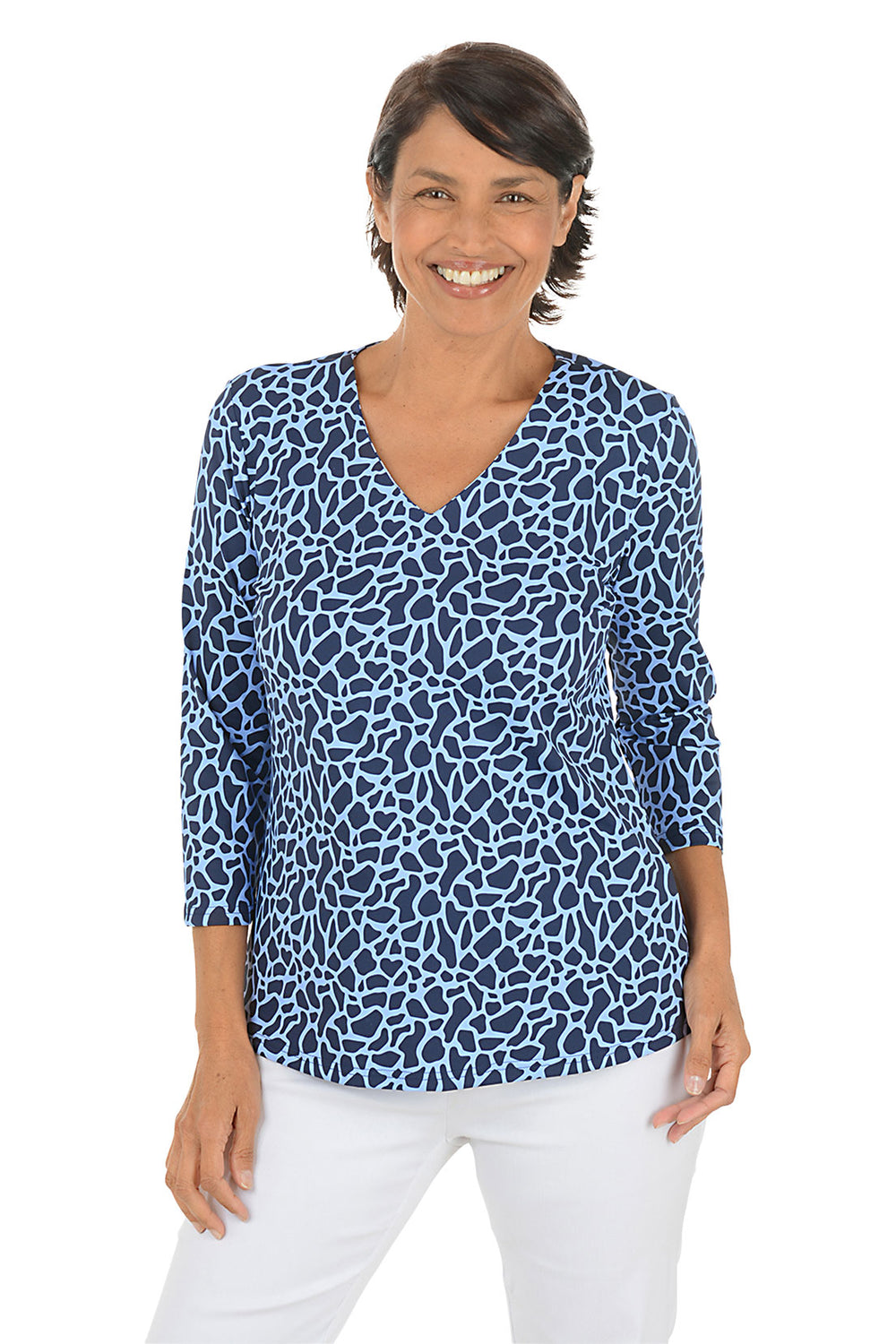 A woman wearing a navy and light blue giraffe print V-neck top with 3/4 sleeves and white pants, shown from the front.