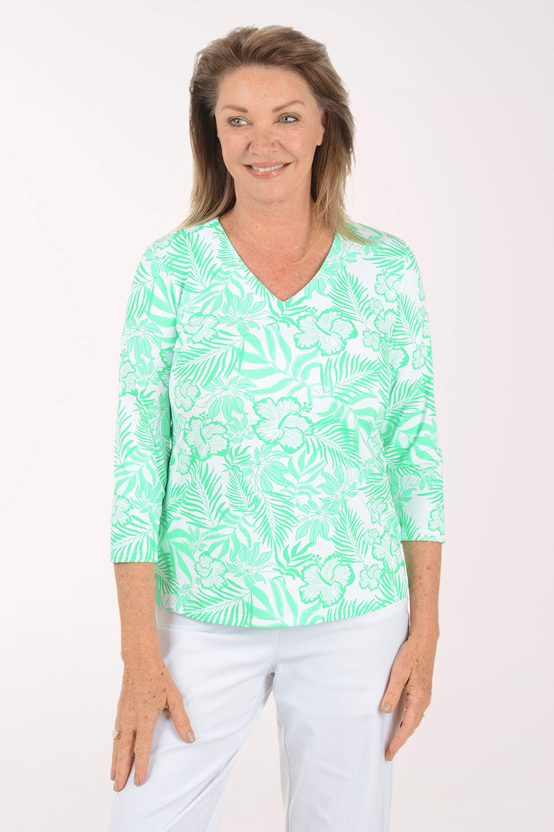 Woman wearing a green and white patterned top on a white background