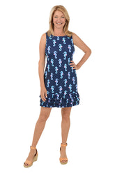 A sleeveless navy dress with a seahorse pattern, featuring a scoop neckline and triple ruffle detail on the hemline. The dress is worn by a model standing against a white background.