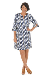 Woman wearing a patterned dress on a white background.