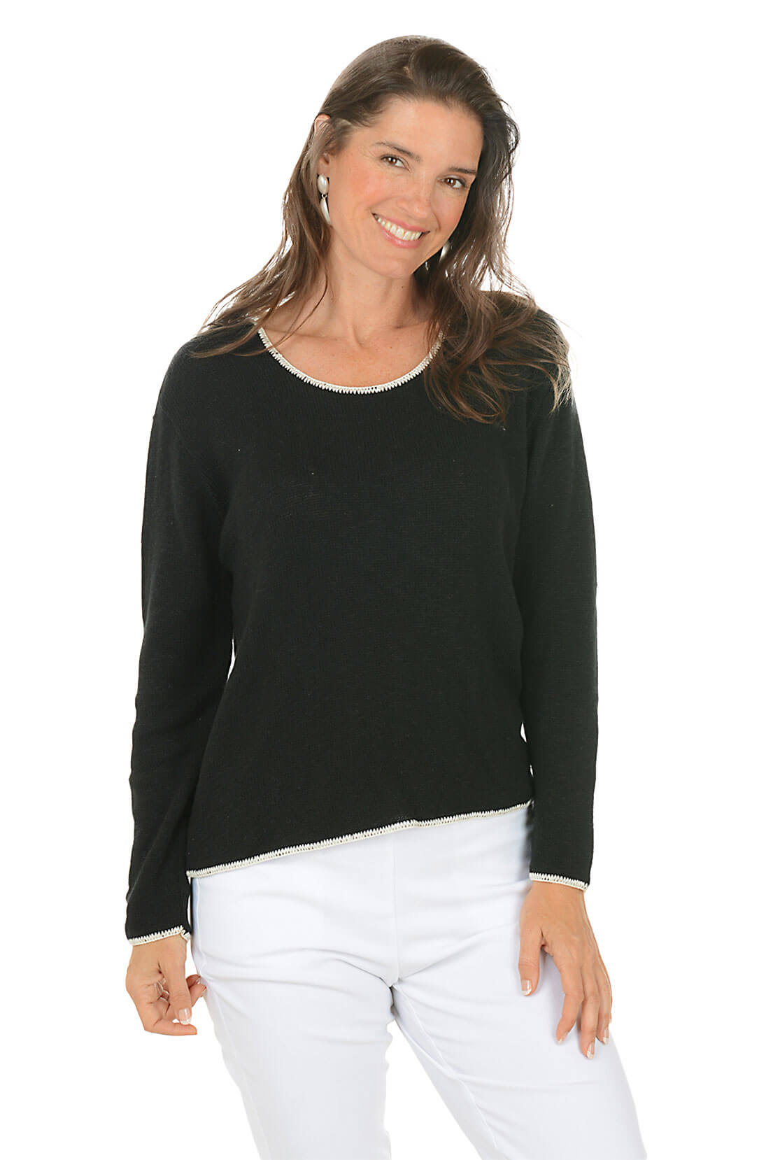 Woman wearing a black long-sleeve top and white pants on a white background