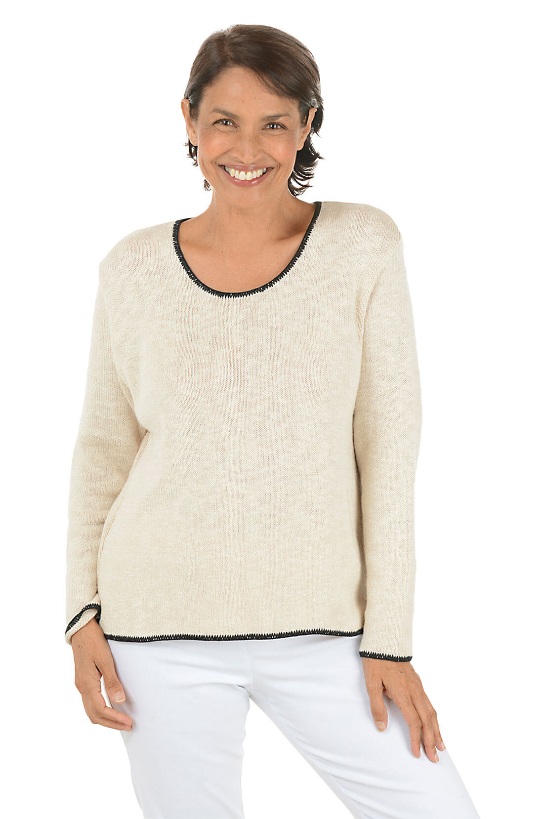 Woman wearing a cream sweater with black trim on a white background