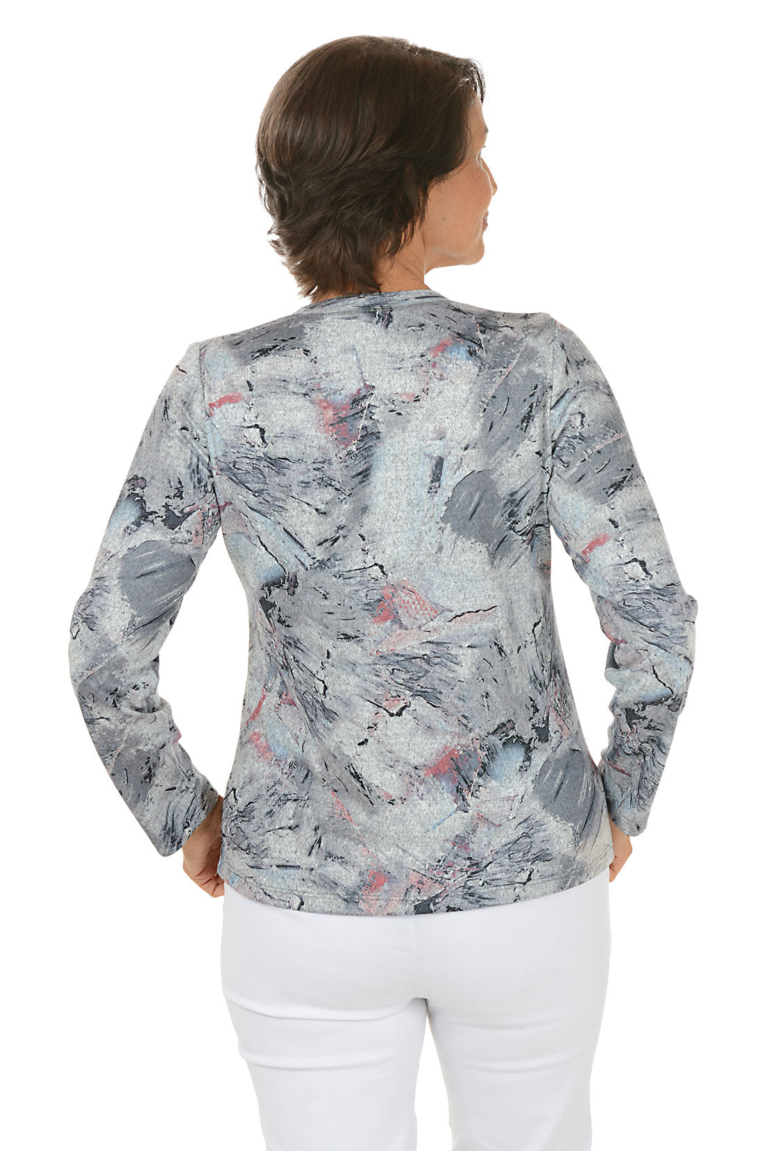 Woman wearing a long-sleeve, patterned top with a white background. Back shot.
