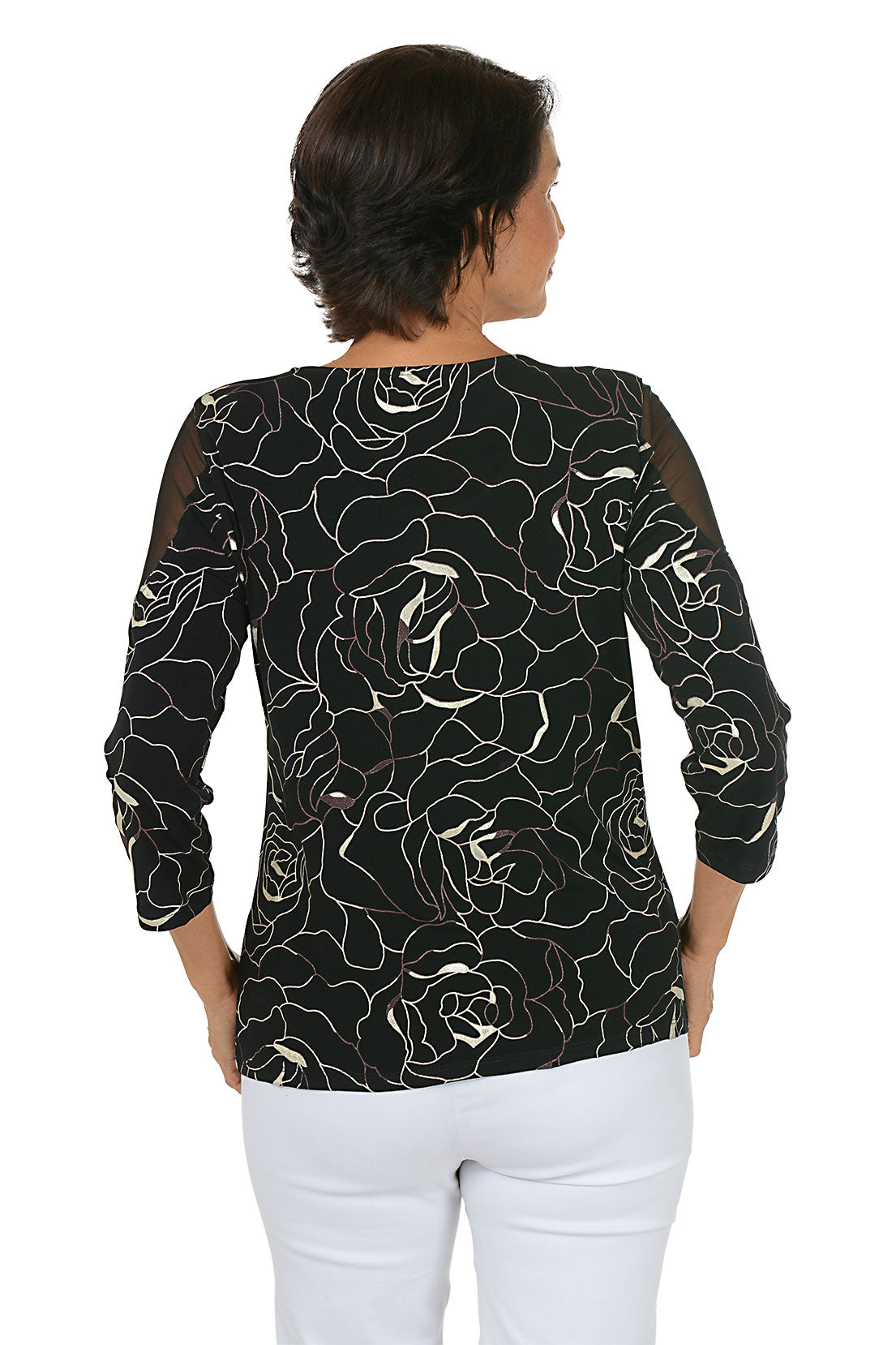 Woman wearing a black floral patterned top on a white background. Back shot.