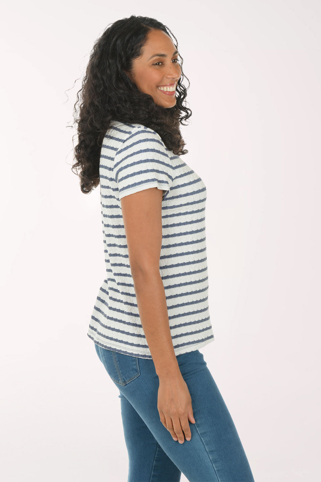 Woman wearing a striped shirt and blue jeans on a white background