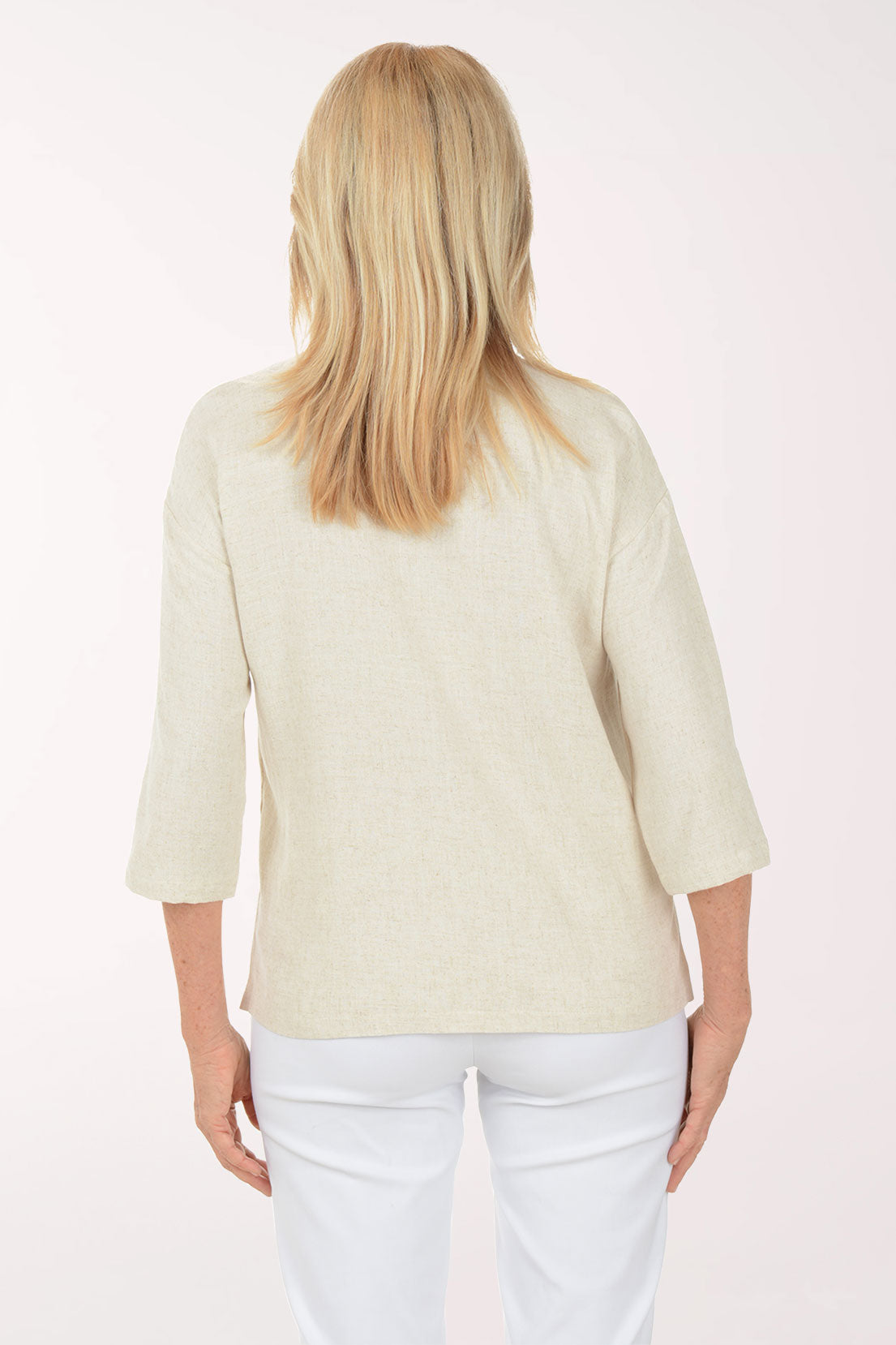 Woman wearing a light-colored blouse with buttons on a white background