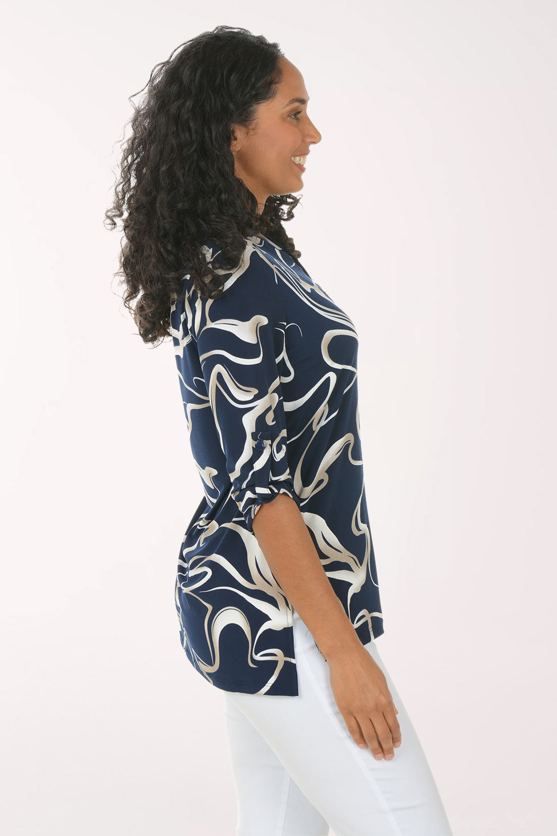 Woman wearing a navy blue and white patterned blouse against a white background