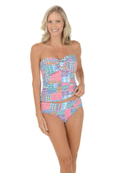 A woman wearing a multli-colored bandeau tankini top swimsuit.