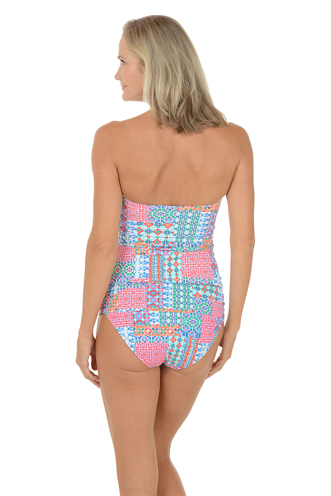 A woman wearing a multli-colored bandeau tankini top swimsuit. Back shot.