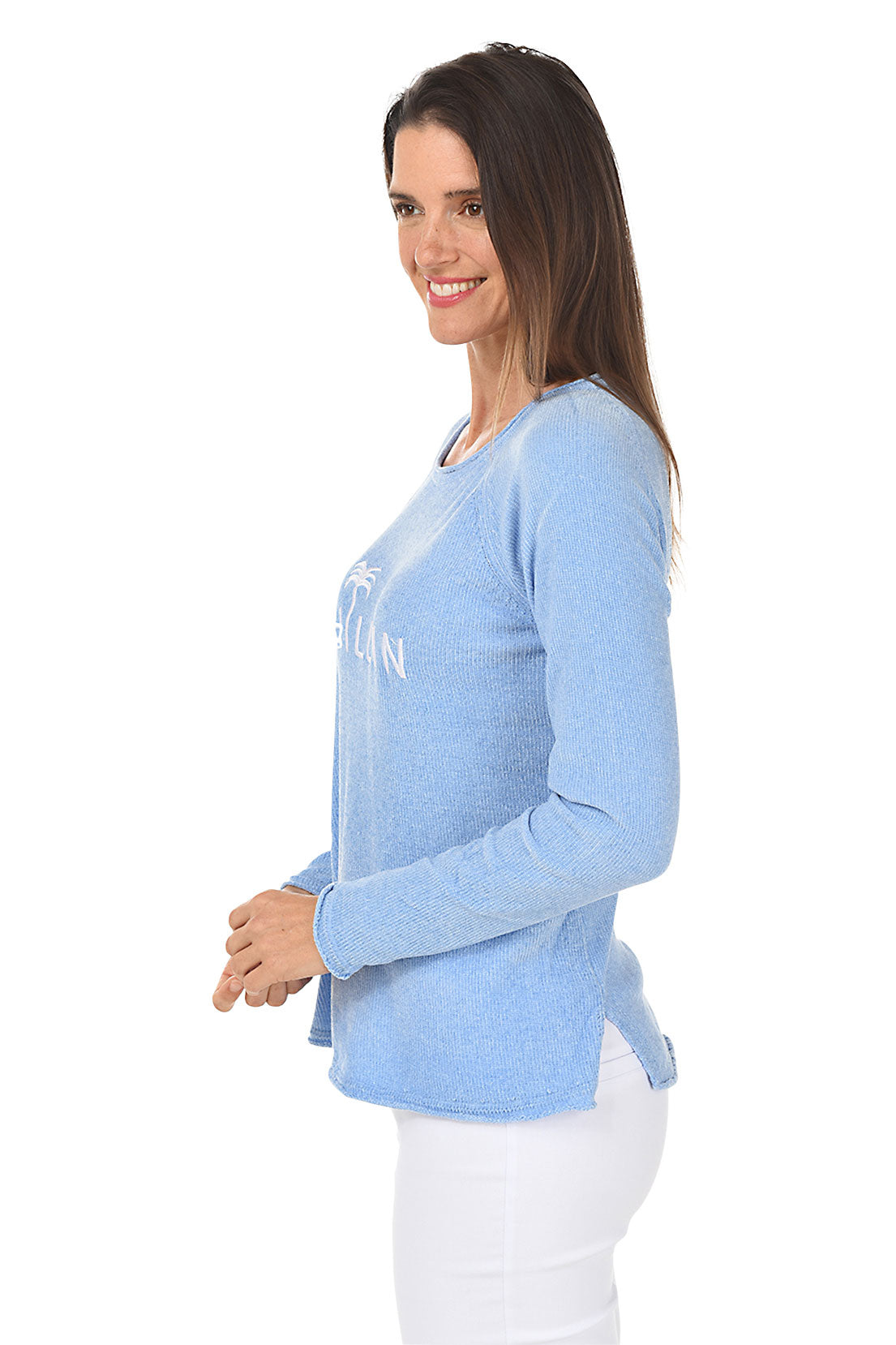 A woman wearing a chenille periwinkle sweater with the words "Chillin" across the chest. Side shot.