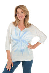 A woman wearing a tie-dye dolman sleeve sweater with a V-neck in blue and white.