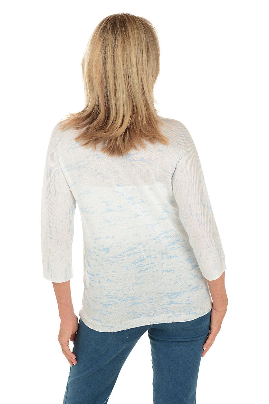 A woman wearing a tie-dye dolman sleeve sweater with a V-neck in blue and white. Back shot.