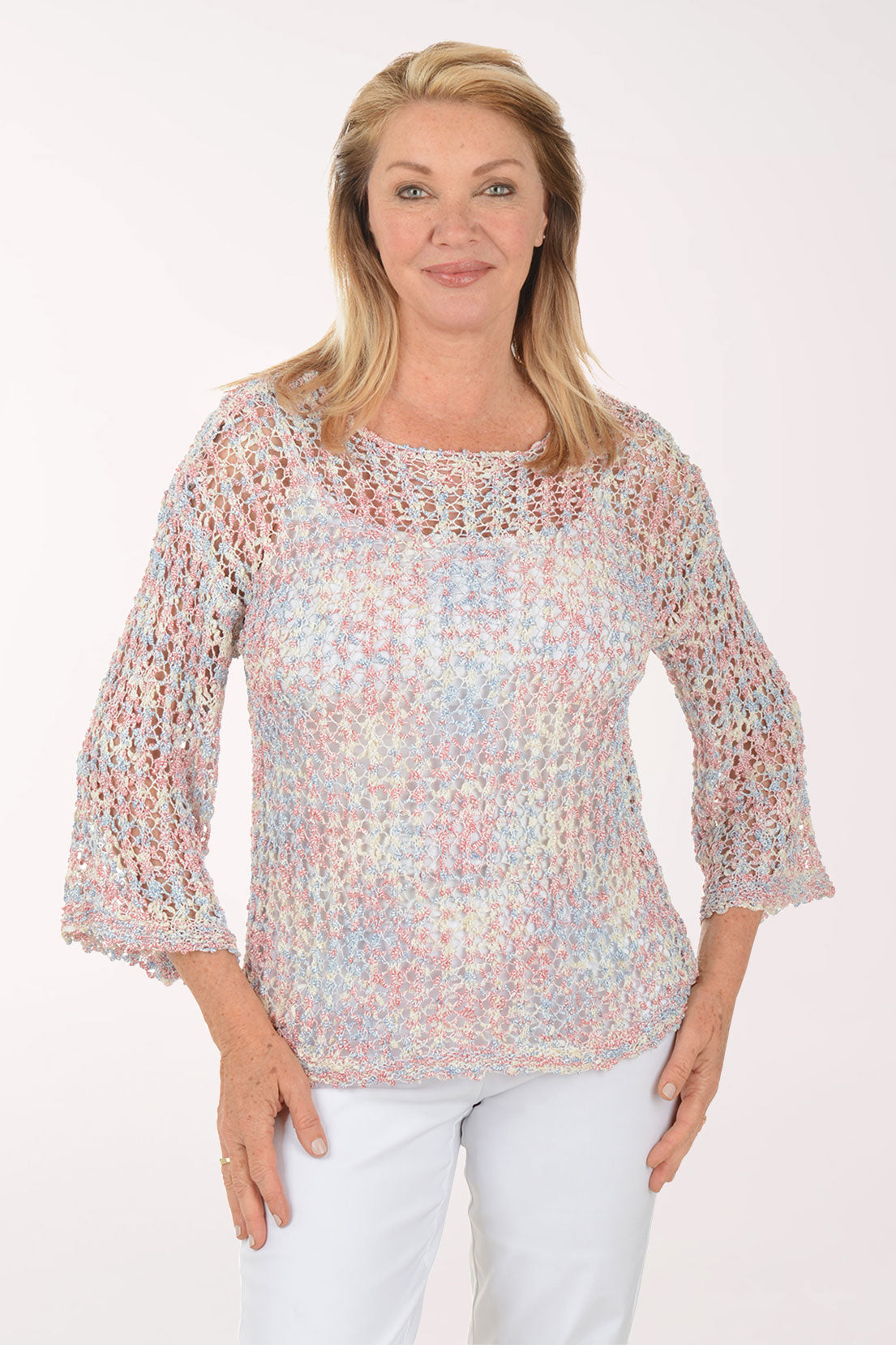 Woman wearing a colorful, patterned blouse against a white background
