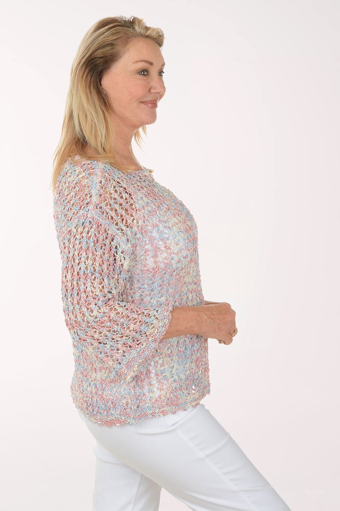 Woman wearing a colorful, patterned blouse against a white background