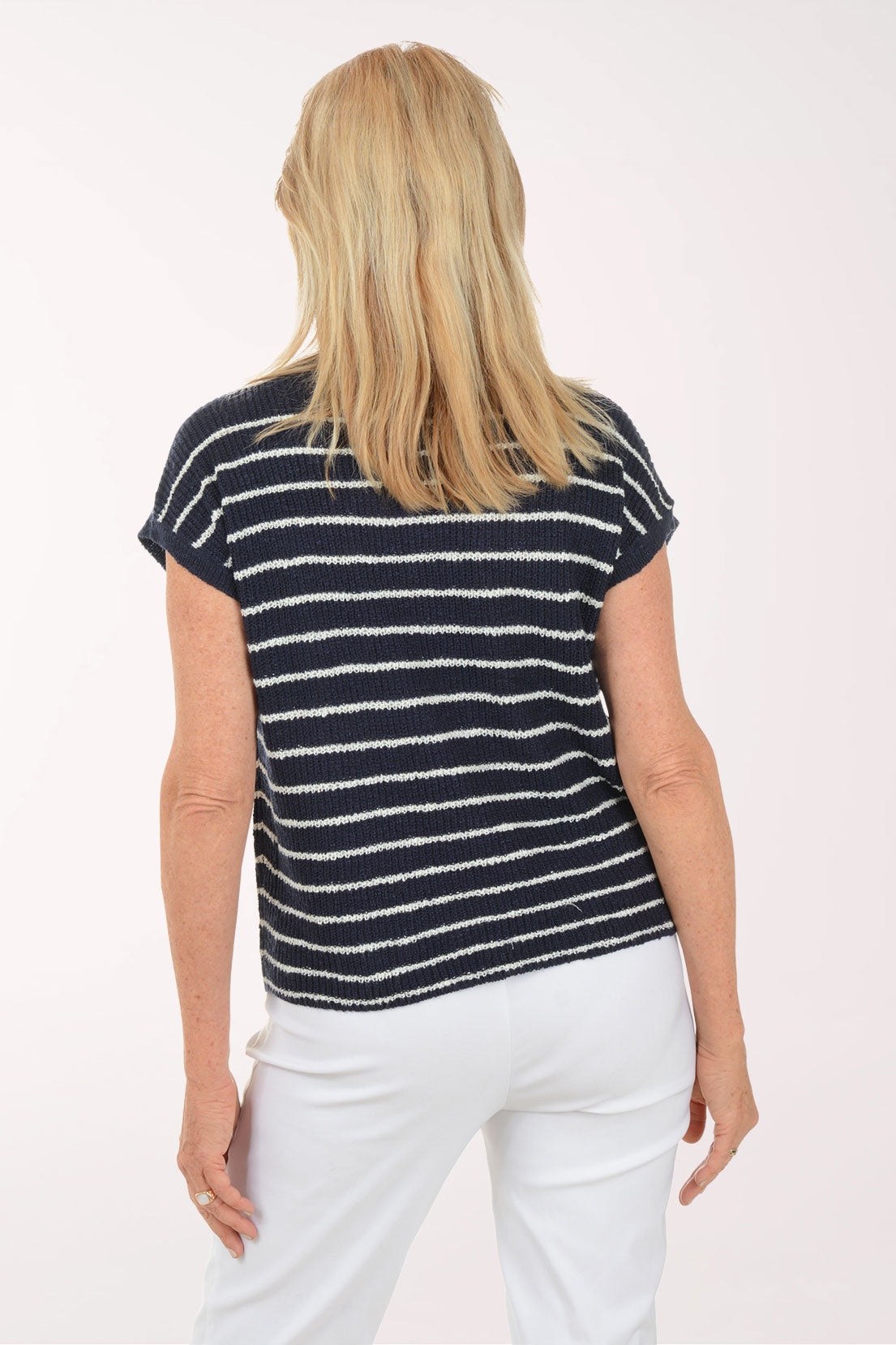 Woman wearing a navy and white striped shirt on a white background