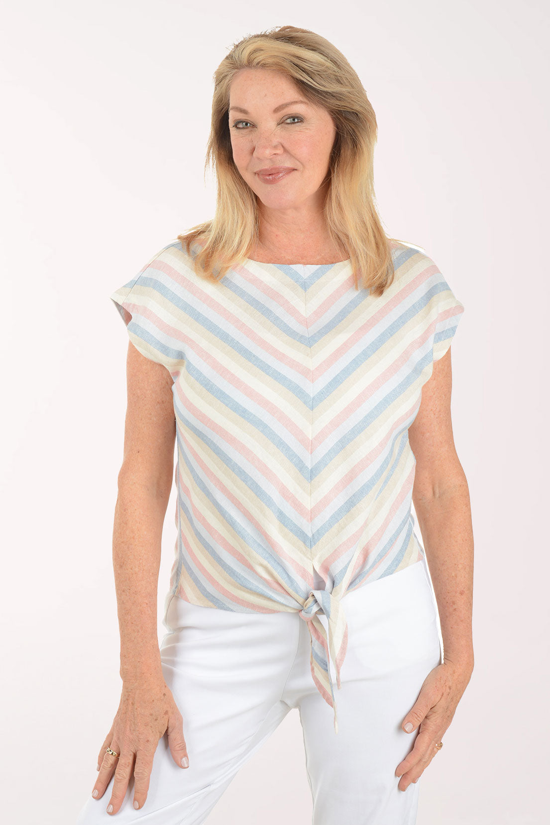 Woman wearing a pastel striped top and white pants on a white background
