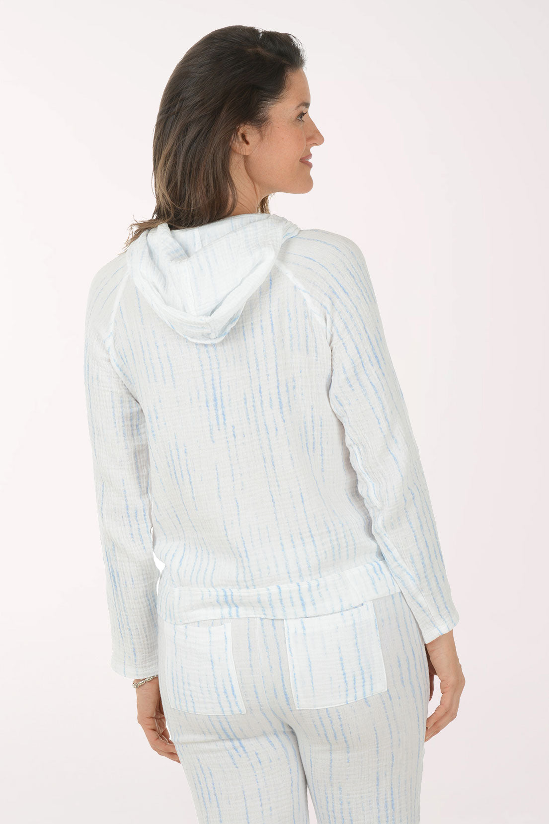 Woman wearing a light blue striped shirt and pants on a white background