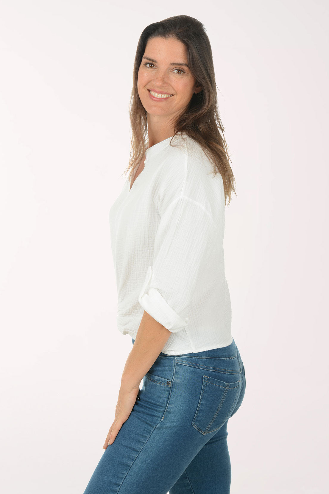 Woman wearing a white blouse and blue jeans on a white background