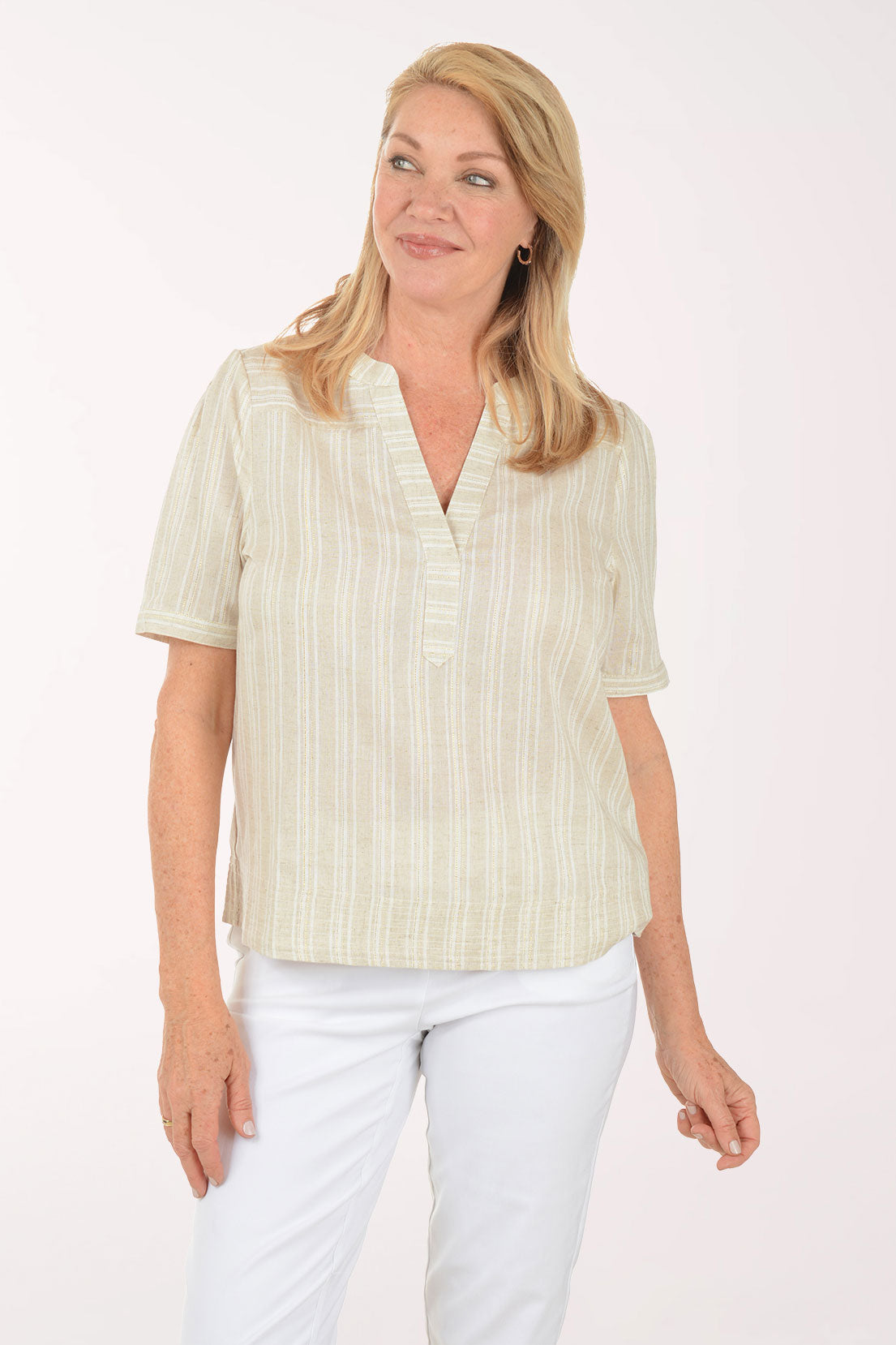 Woman wearing a light-colored striped shirt and white pants on a white background