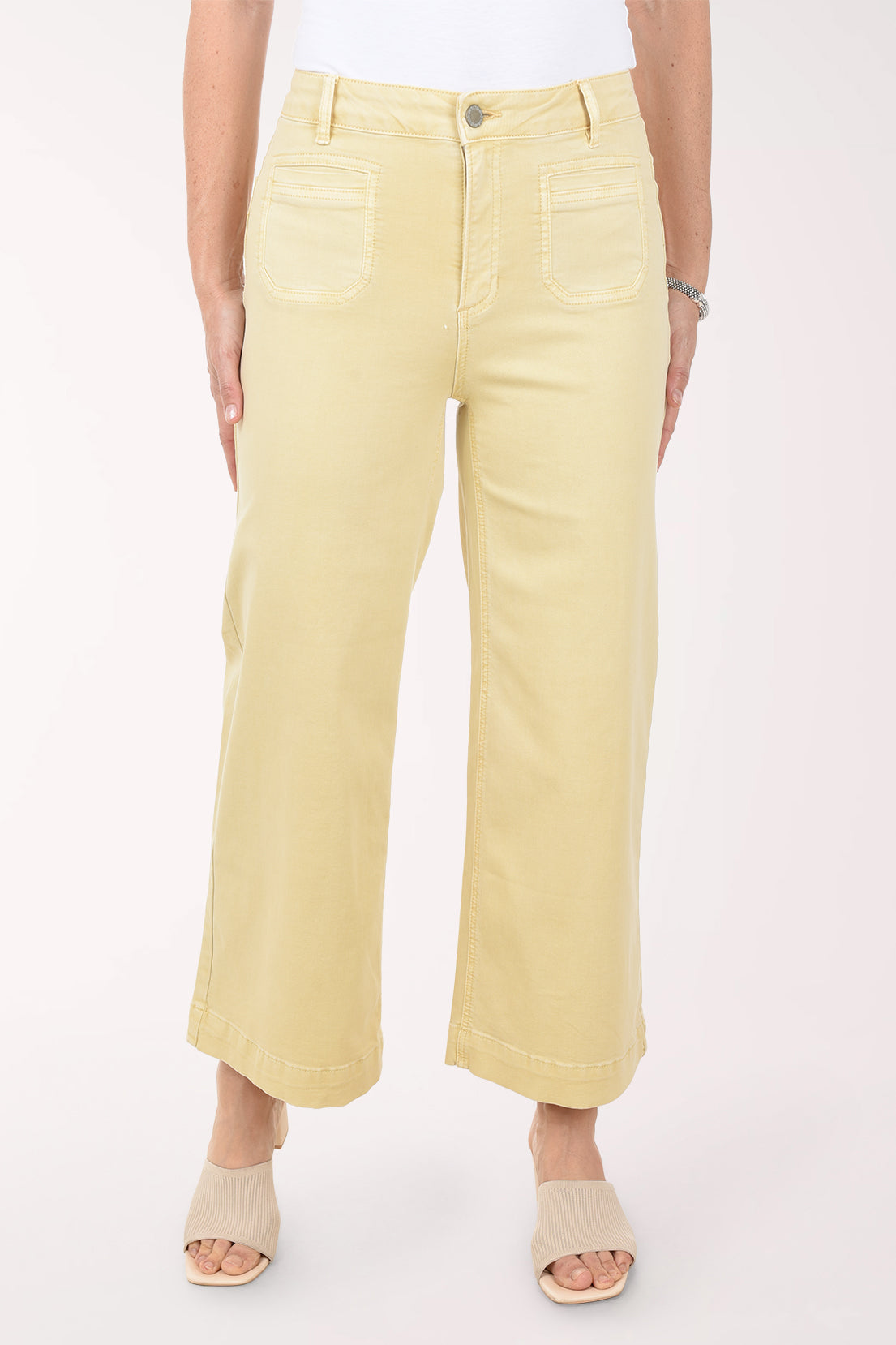 Person wearing light yellow pants on a white background